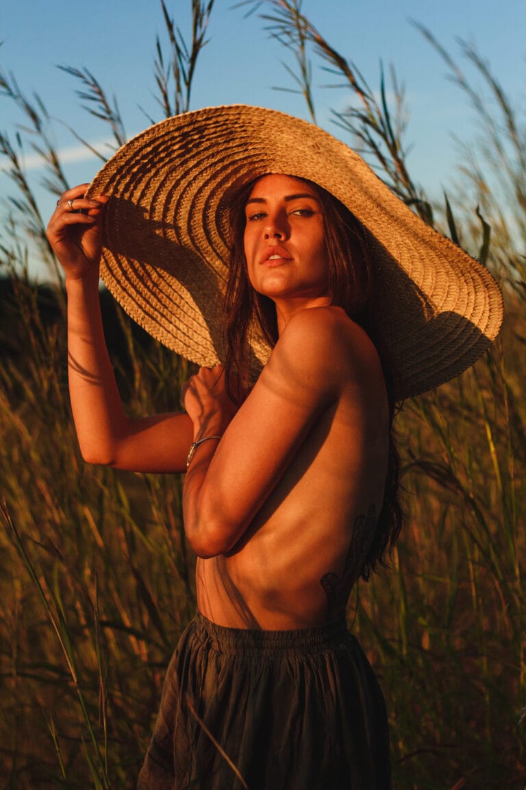 Portrait photography Gold Coast - wide-brim hat in tall summer grass at sunset
