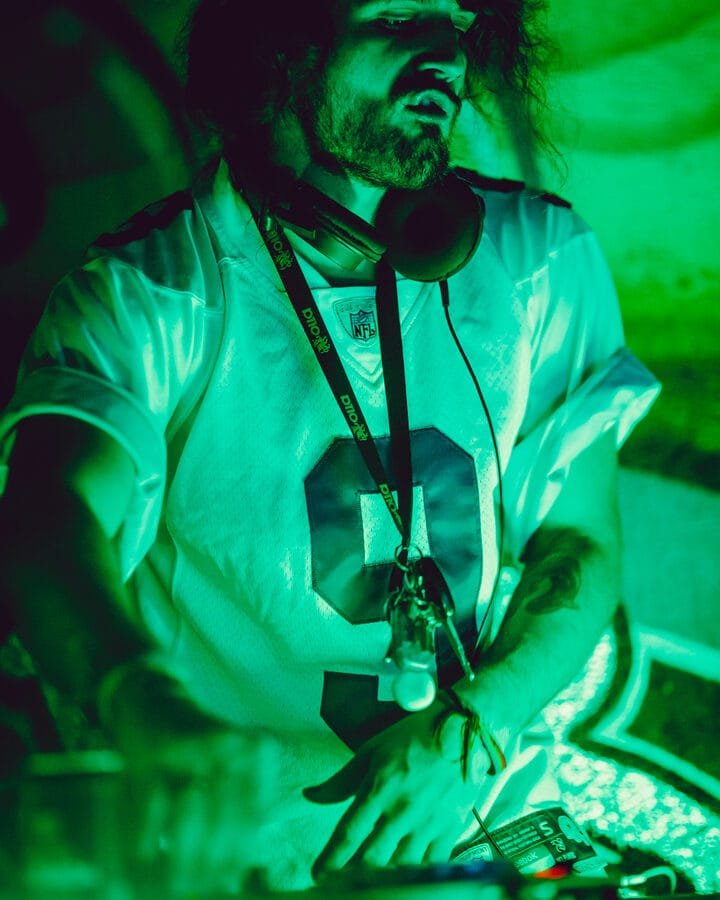 DJ playing under green light, event videography in Gold Coast