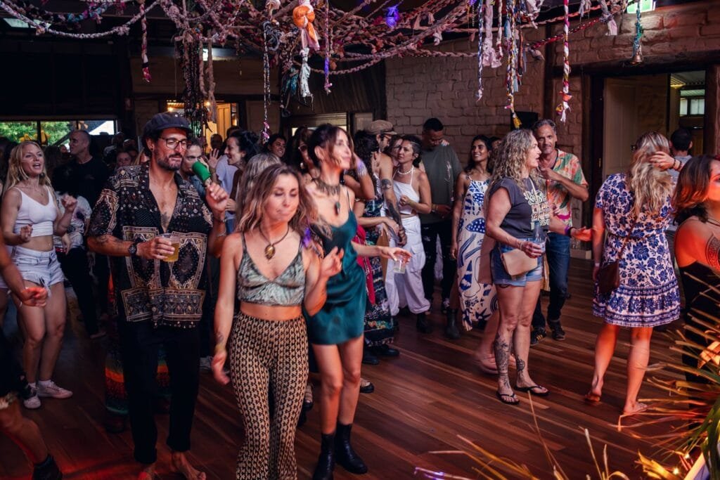 Guests dancing under string lights at an indoor party, event photography