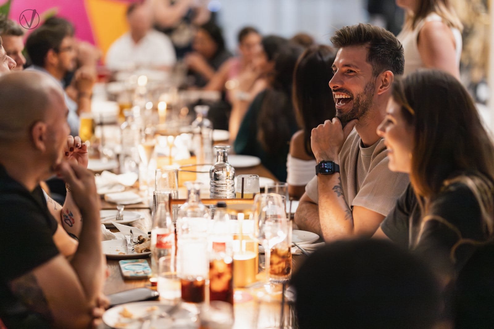 Guests laughing around a long table at an event in Gold Coast