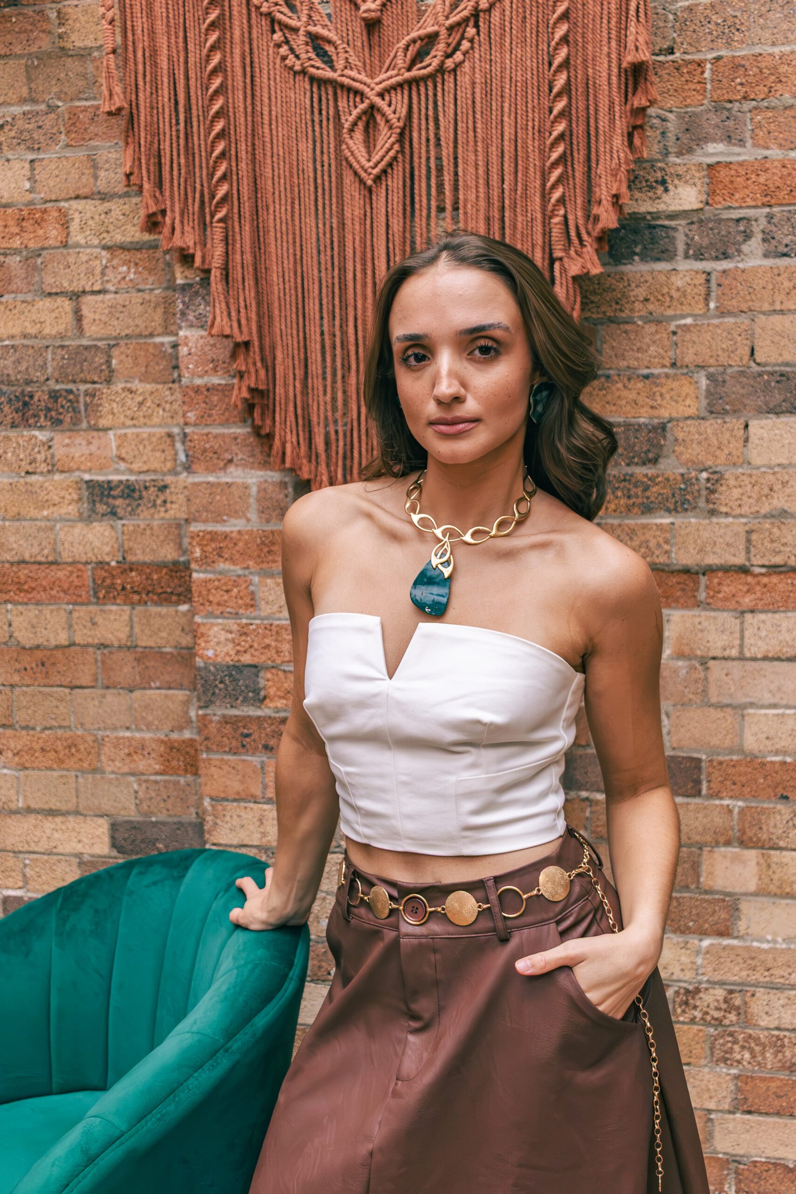 Guest portrait against brick and macrame at The Hills of Rivermakers